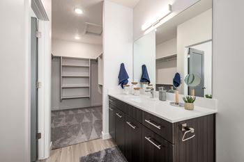 A bathroom with a sink, mirror, and towel rack.
